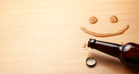 Beer smile. Beer bottle and spilled drink on the table. Copy space for text.