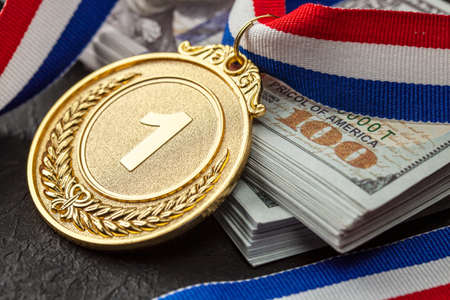 Bribe in sports for victory. Gold medal award and a stack of money dollarsの写真素材