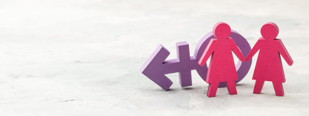 Couple of lesbians holding hands on transgender symbol backgroundの写真素材