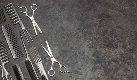 Black combs and combs with scissors on a black background. Copy space for text.の写真素材