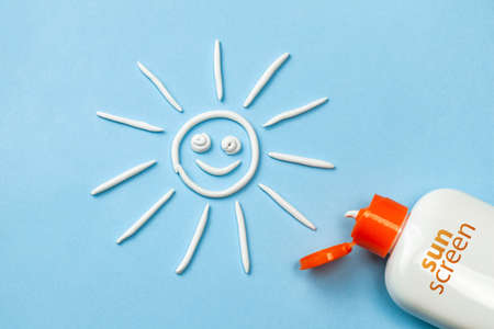 Sunscreen. Cream in the form of sun on blue background with white tubeの写真素材