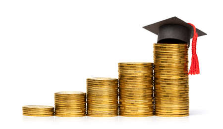 Stack of coins steps up and graduate hat. Concept is an expensive education, investing in yourself. isolated on white background.の写真素材