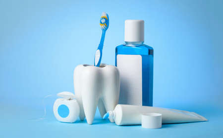 Set for cleaning teeth and mouth. Toothpaste, toothbrush, dental floss and mouthwash on a blue backgroundの写真素材