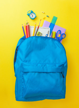 School bag. Backpack with supplies for school on yellow background. Copy space for textの写真素材