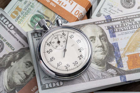 Money and stopwatch. Dollars banknotes and stopwatch. Time is moneyの写真素材