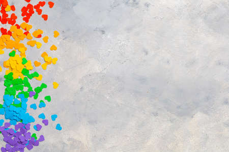 Small hearts in rainbow colors as a symbol of LGBT flag on gray. Template Copy space for textの写真素材