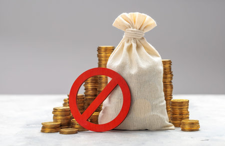 Prohibition sign. Money bag and stacks of coins on a gray background. No symbol and money