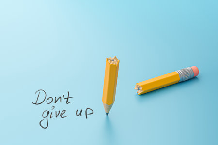 Don't give up. Broken pencil in half on a blue background.の写真素材