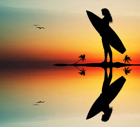 Girl surfing at sunsetの写真素材