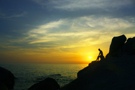man on the cliff at sunsetの写真素材