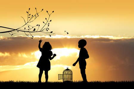 children with bird cage at sunsetの写真素材