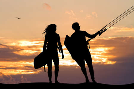 surfers couple at sunsetの写真素材
