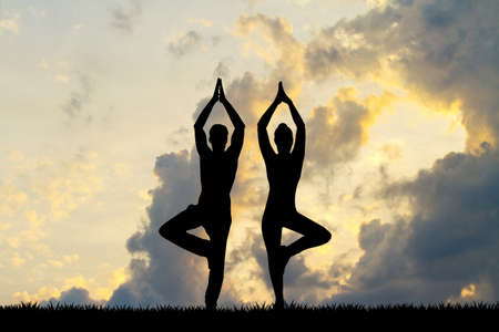 couple doing yoga at sunsetの写真素材
