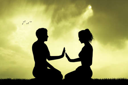 couple doing yoga at sunsetの写真素材