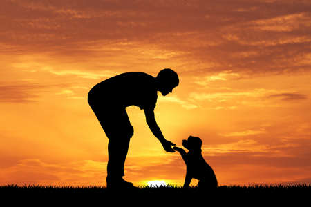 man with puppy at sunsetの写真素材