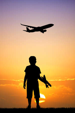 child with airplane at sunsetの写真素材