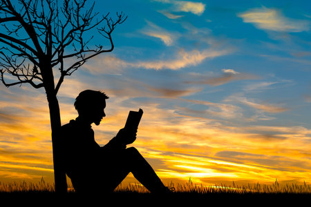 man reading a book at sunset