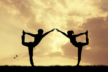 couple doing yoga at sunsetの写真素材