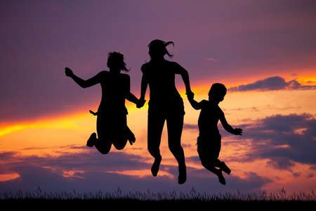 Happy boys and girls at sunsetの写真素材