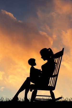 mom cuddles the baby sitting outdoorsの写真素材