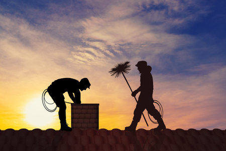 chimney sweep on the roof at sunset