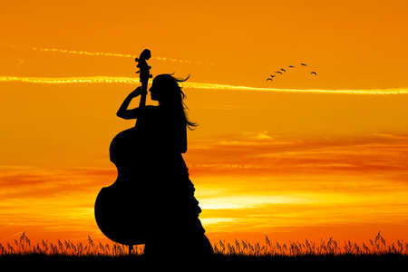 woman plays the cello at sunsetの写真素材