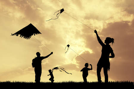 family with kite at sunsetの写真素材