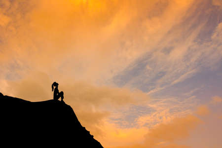 girl sitting on top of the mountainの写真素材