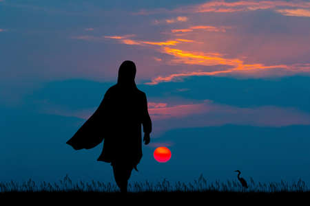 silhouette of muslim woman at sunsetの写真素材