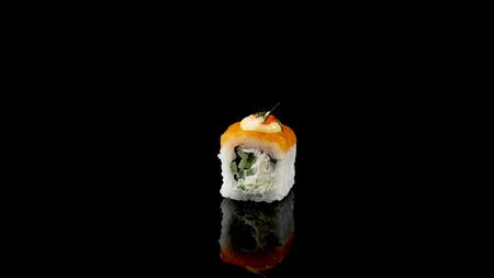sushi roll with salmon and caviar on black background rotating.の写真素材
