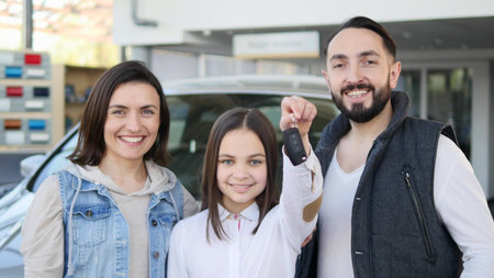 Happy baby girl holding keys to new family car.の写真素材