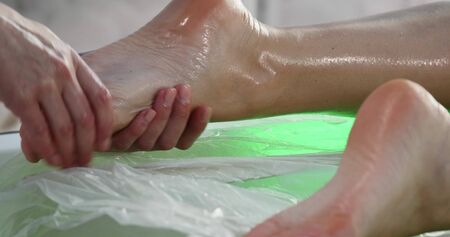 Massage specialist doing massage of womans feet at beauty spa.の写真素材