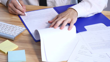 Businessman signing documents on office table.