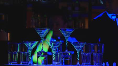 barman show. Two barmen juggle bottles and Beaker for mixing . close up.の写真素材