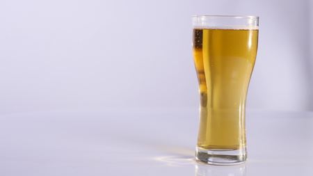 Man with a glass of beer. white background. close up.の写真素材