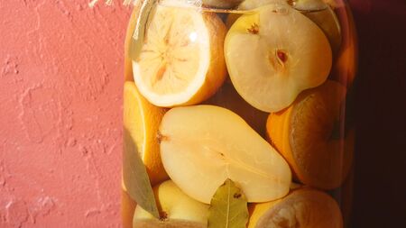 Jar of apple and lemon compote on a red background.の写真素材
