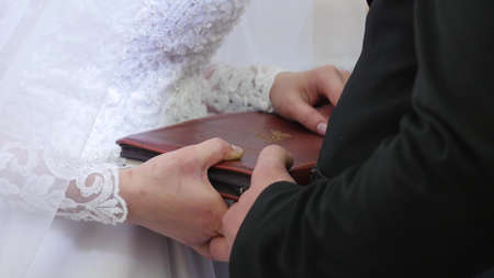 Bride And Groom Hands On Bible. Bride and Groom place their hands on the bible to exchange vowsの写真素材