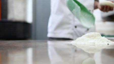 The chef's hands roll the dough into pizza.