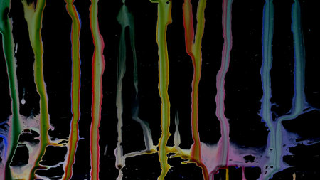 Colorful Ink droplets slide on glass black background.の写真素材
