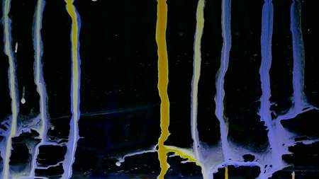 Colorful Ink droplets slide on glass black background.の写真素材