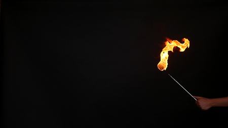 Fire show performance. A man picks gasoline at a torch, slow motion.の写真素材