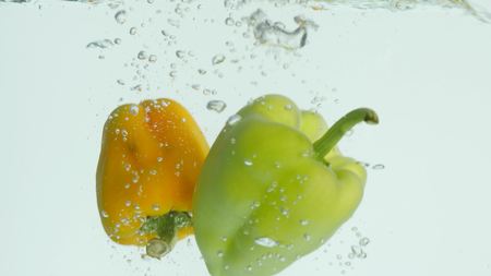 Bell pepper falls in water.の写真素材