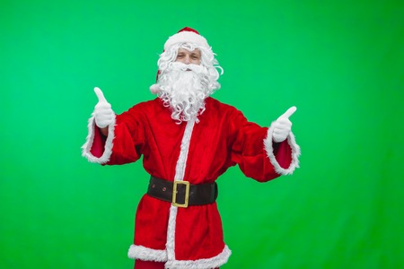 Santa with thumbs up isolated over a green background.の写真素材