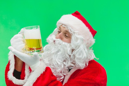 Father Christmas Santa looks at a lovely glass of beer. chroma key. close up.の写真素材