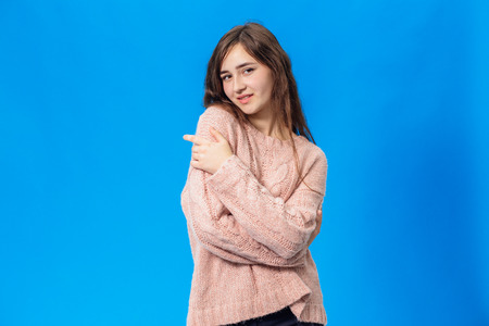 Young beautiful girl isolated on blue backgroundの写真素材