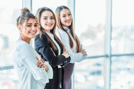 With pleasure, three business women cross their arms, looking at the camera.の写真素材
