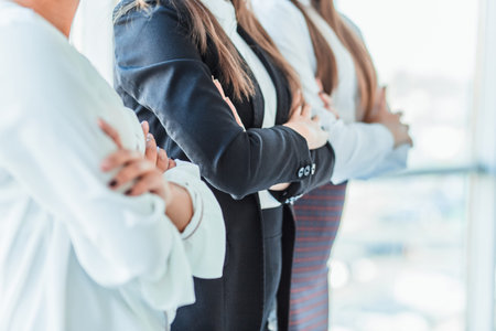 With pleasure, three business women cross their arms, looking at the camera.の写真素材