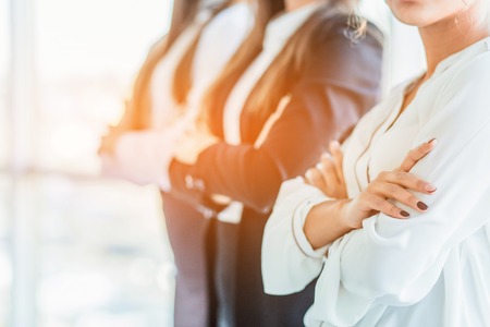 With pleasure, three business women cross their arms, looking at the camera.の写真素材