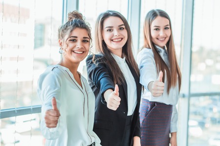 Three young business girls in the office. Dressed in classic clothing styleの写真素材