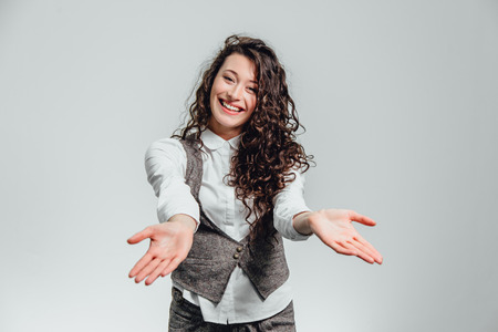 Portrait of attractive business woman on white background. With plenty of copy space. With pretty curly hair, turning your hands in different directions.の写真素材